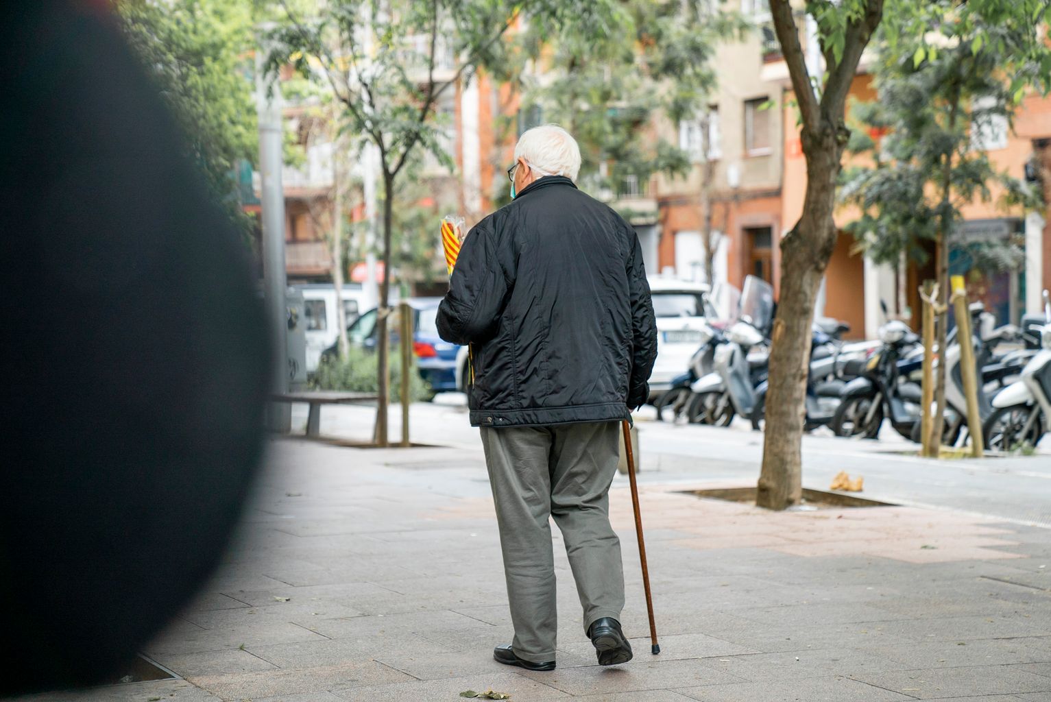 Un home gran marxa del quiosc de Diverscoop amb una rosa a la mà