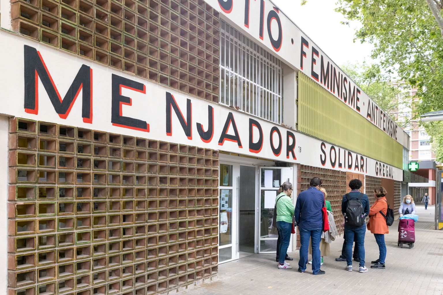 Gent conversant davant del Menjador Solidari Gregal