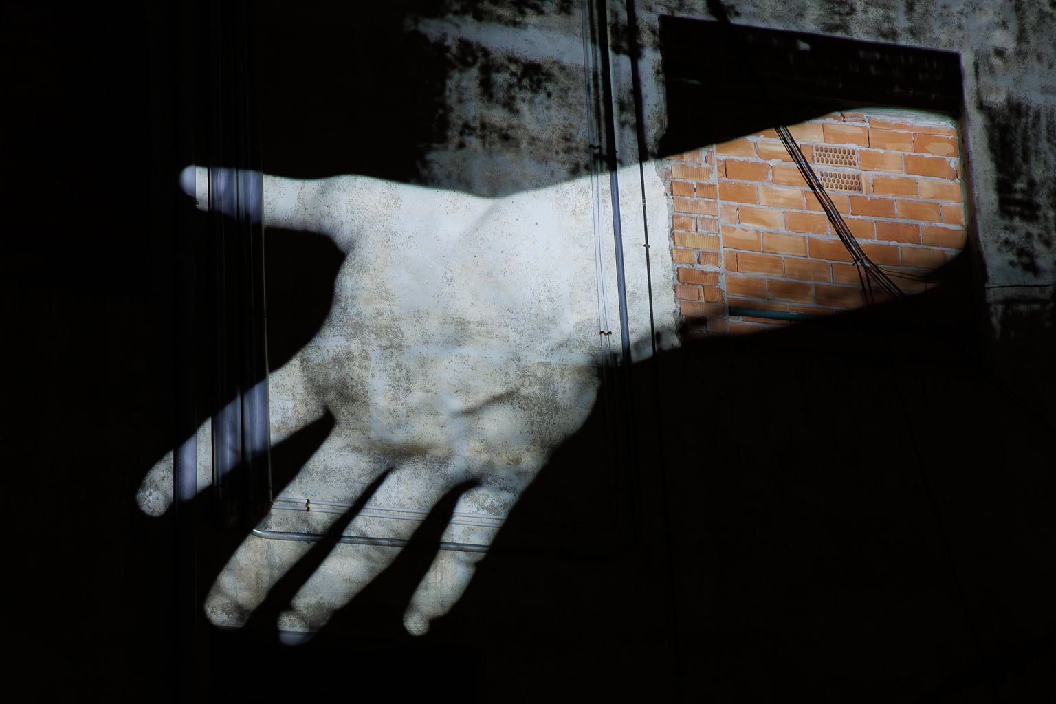 Una mà projectada a un mur. “Behind the Walls”, obra de Nathalie Maufroy. A la Casa de les Lletres - pl. Dolors Piera (Sancho de Ávila, 135)