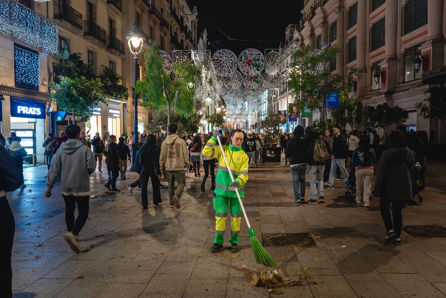 Una operària de Cuidem Barcelona escombra el Portal de l’Àngel