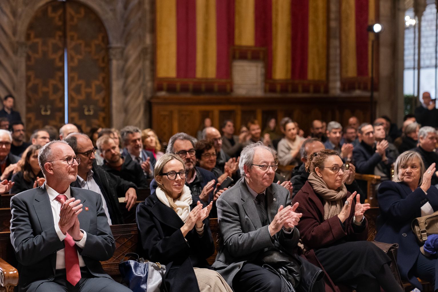 Pla general de part del públic assistent a l’acte de presentació de la Biennal Ciutat i Ciència 2023 al Saló de Cent de l’Ajuntament de Barcelona, aplaudint una de les diferents intervencions.