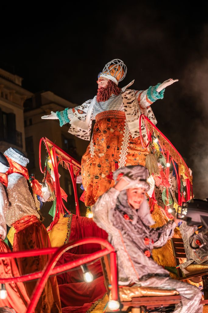 El rei Gaspar saluda des de la carrossa acompanyat dels patges reials