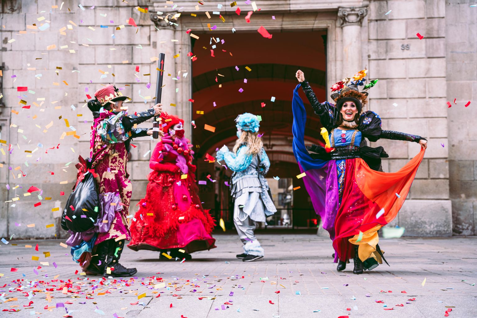 Ball del rei Carnestoltes, la reina Belluga i el seu seguici davant de la porta del Palau de la Virreina mentre tiren confeti