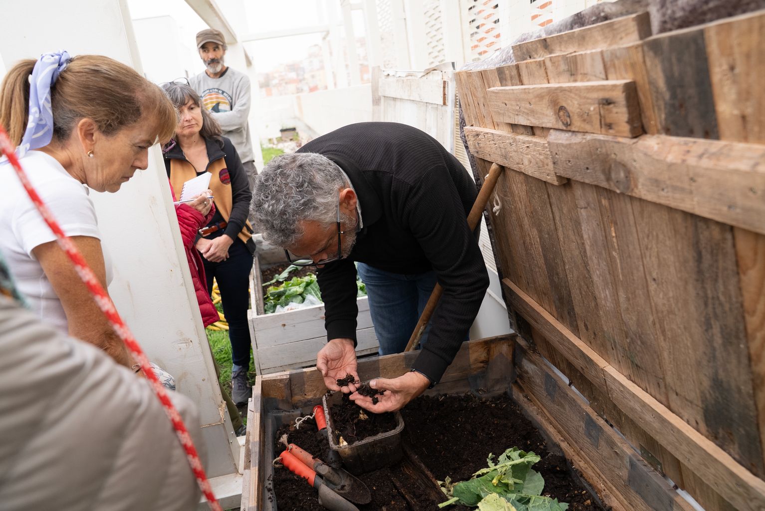 Una persona reparteix el compost vegetal de l'hort del Mercat de la Vall d'Hebron