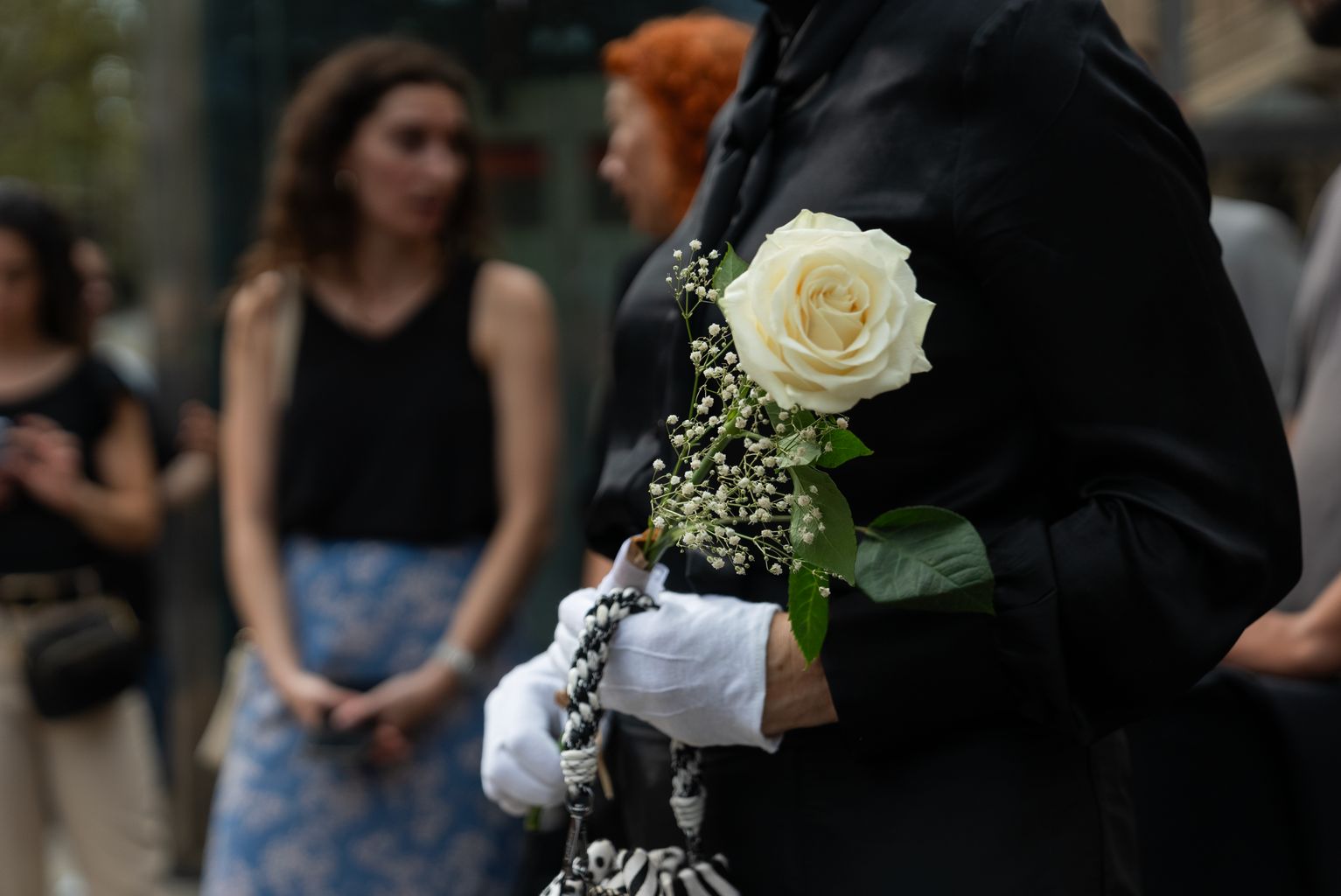 Una rosa groga en senyal de respecte a les mans d’un familiar de les víctimes de l’atemptat