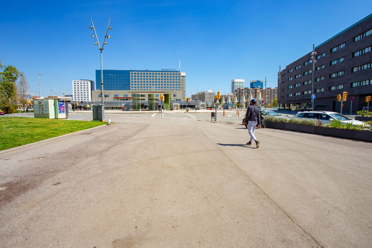 Plaça de Joan Peiró i passeig de Sant Antoni prop de Sants Estació per on camina una persona. Districte de Sants-Montjuïc. Barri de Sants. 