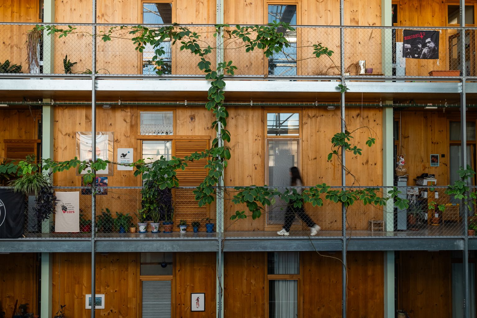 Una noia caminant per un passadís interior de l’habitatge cooperatiu La Borda.