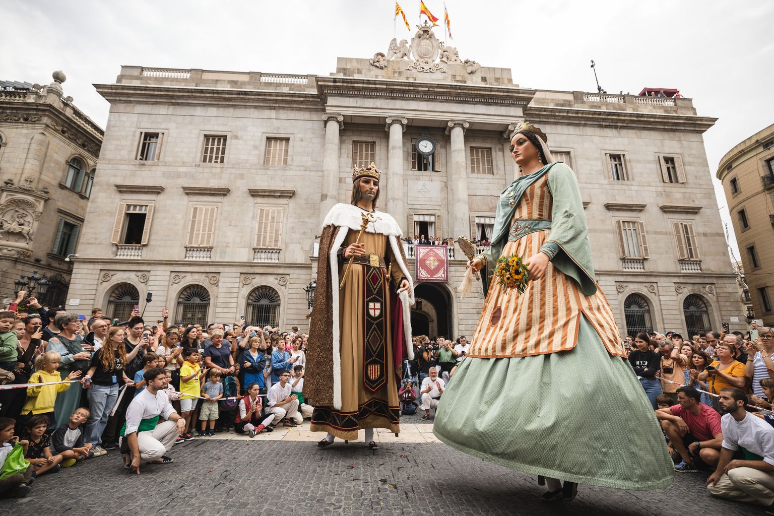 Baile de los Gegants de la Ciutat en la plaza de Sant Jaume rodeados de los miembros de la 'colla' y del público asistente al séquito de La Mercè