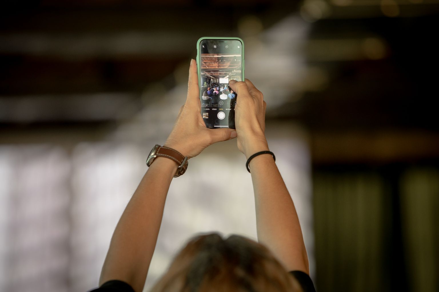 Una persona fotografia amb el mòbil l'escenari on té lloc l'activitat "Set mirades fílmiques sobre Barcelona II. Simfonies de ciutat"