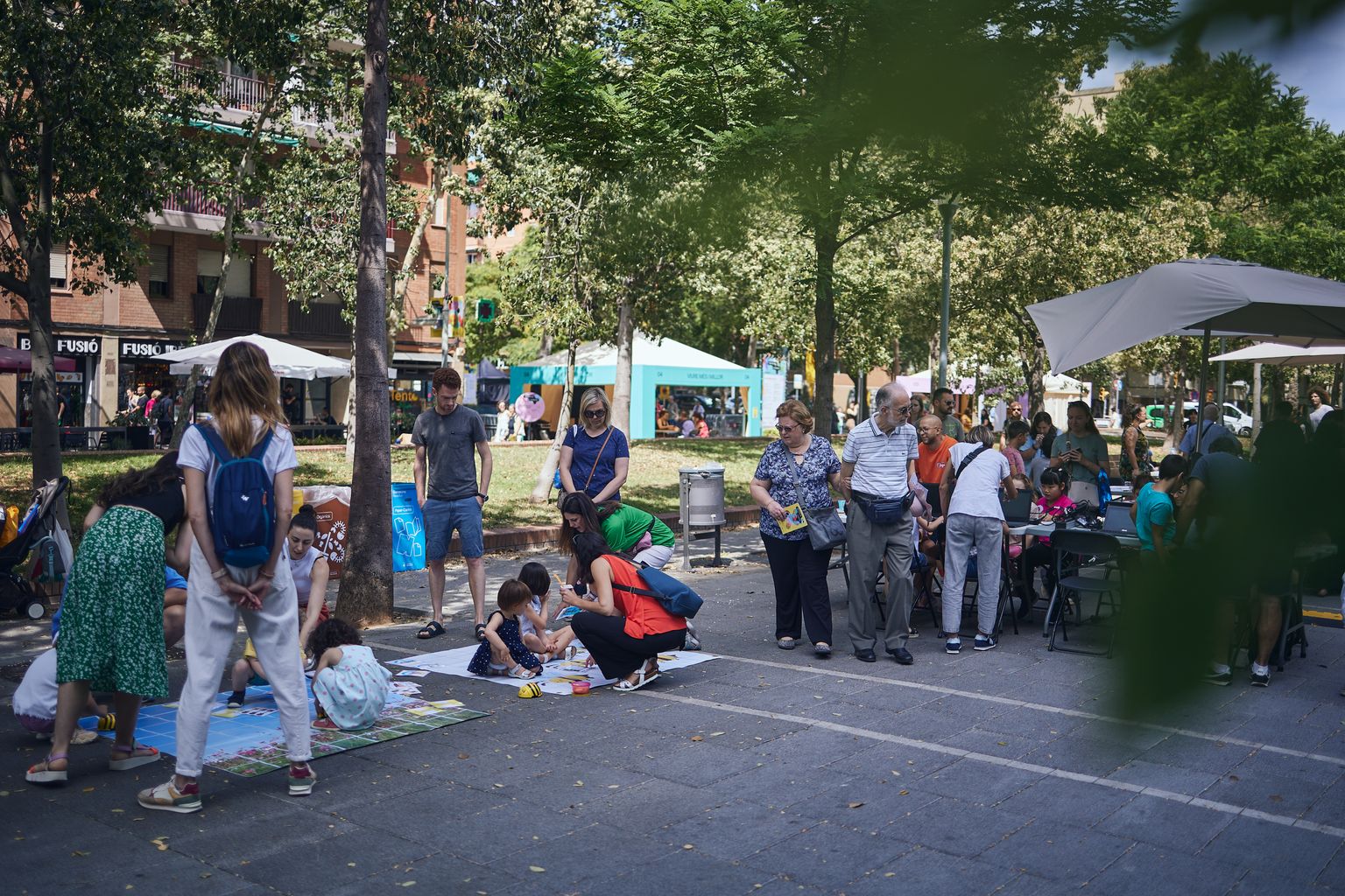 Gente participando en las diferentes actividades de la 16.ª Fiesta de la Ciencia en la rambla de Prim.