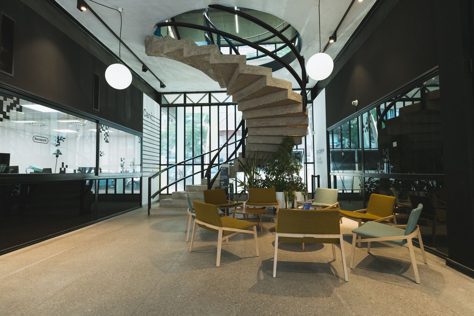 Vestíbul de l'equipament municipal El Canòdrom - Ateneu d'Innovació Digital i Democràtica amb unes escales de cargol d'accés al pis superior