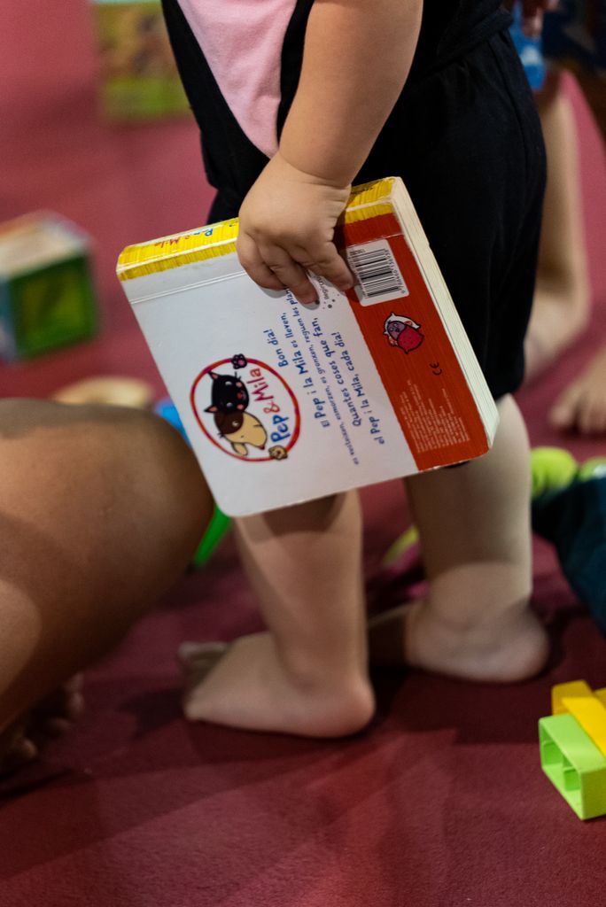 Un infant agafa un llibre de contes infantils al taller “Contes per a les Comunitats del Gel”