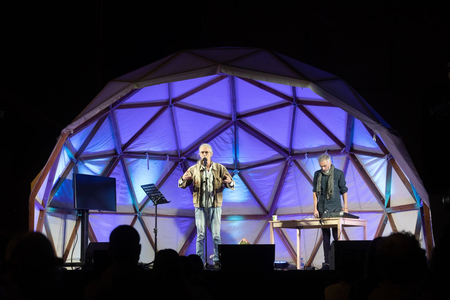 Taula rodona i performance "Mirar el futur". Dalt de l'escenari, el poeta Enric Casasses acompanyat d'Ilia Mayer presenta el seu manifest poètic per al futur