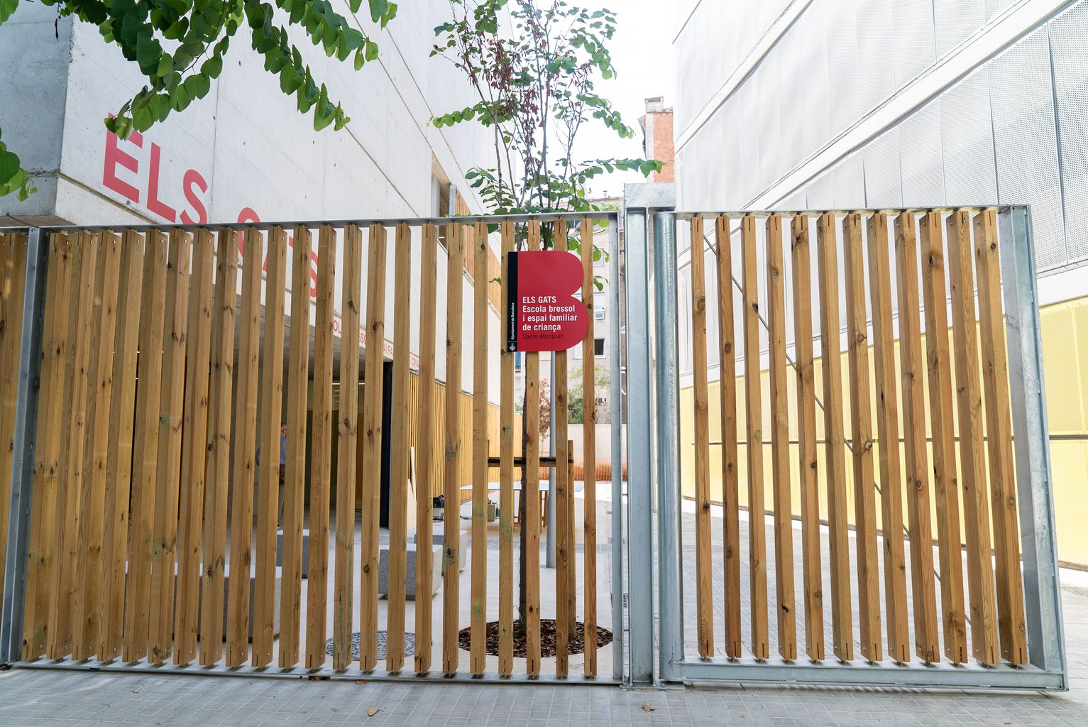 Porta de fusta d'accés a l'escola bressol municipal Els Gats