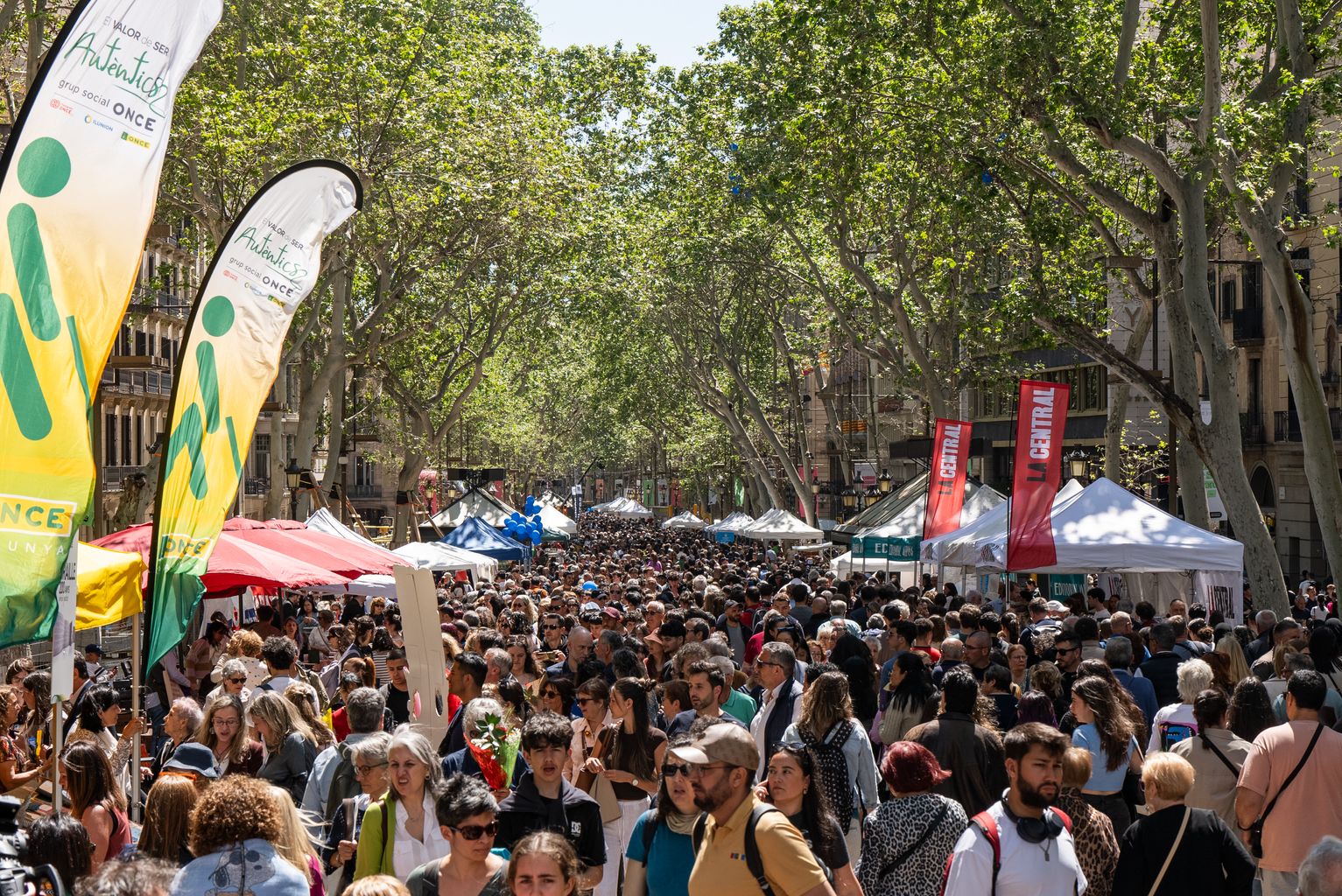 La Rambla llena de gente y con muchos puestos el Día de Sant Jordi
