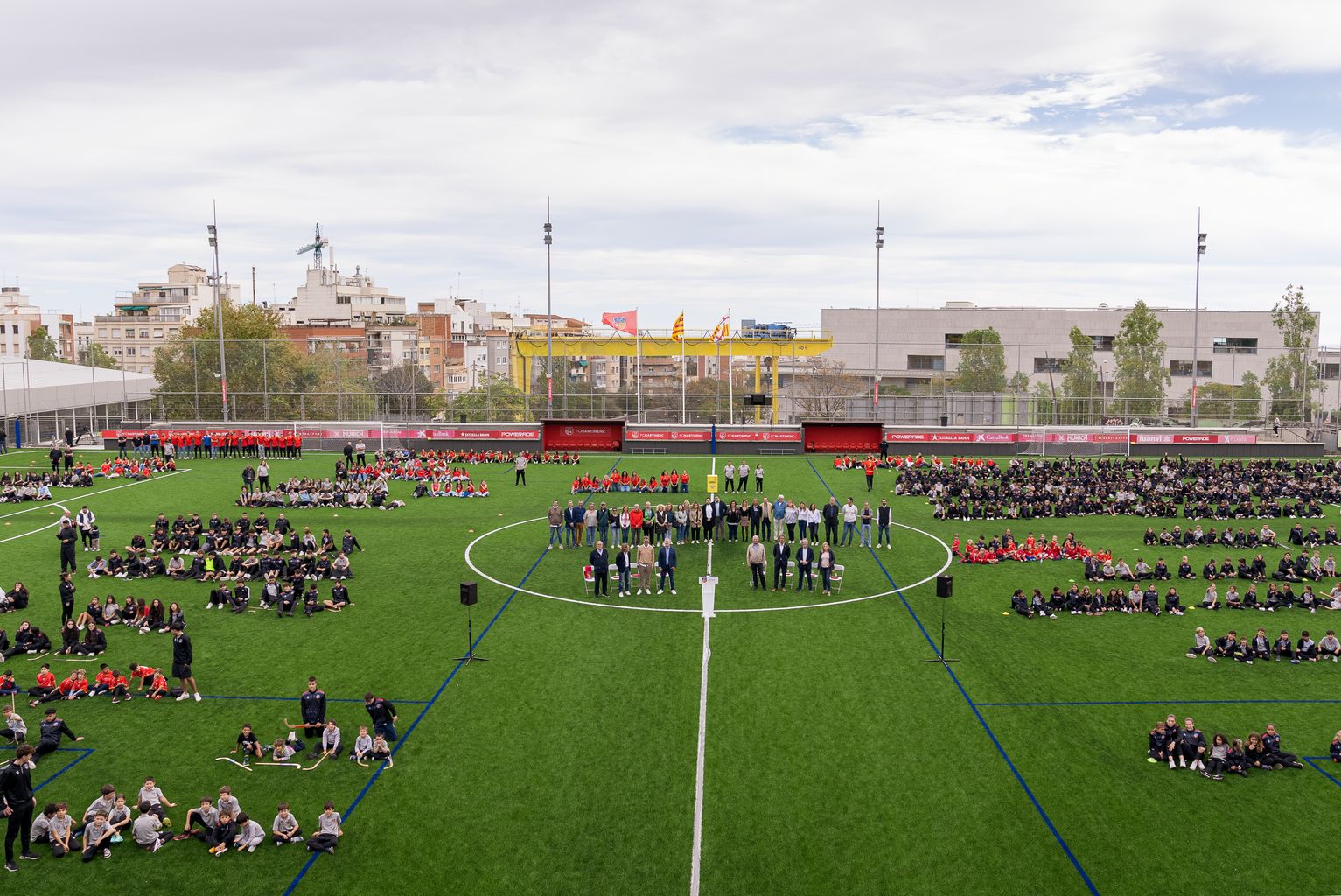 Vista en alçada dels equips del Club Esportiu Martinenc al seu camp durant l’acte d’inauguració de la nova gespa i presentació dels equips del club