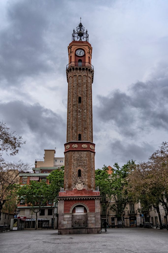 Plaza de la Vila de Gràcia con la torre del reloj y, alrededor, los negocios de restauración cerrados. Distrito de Gràcia. Barrio de la Vila de Gràcia.