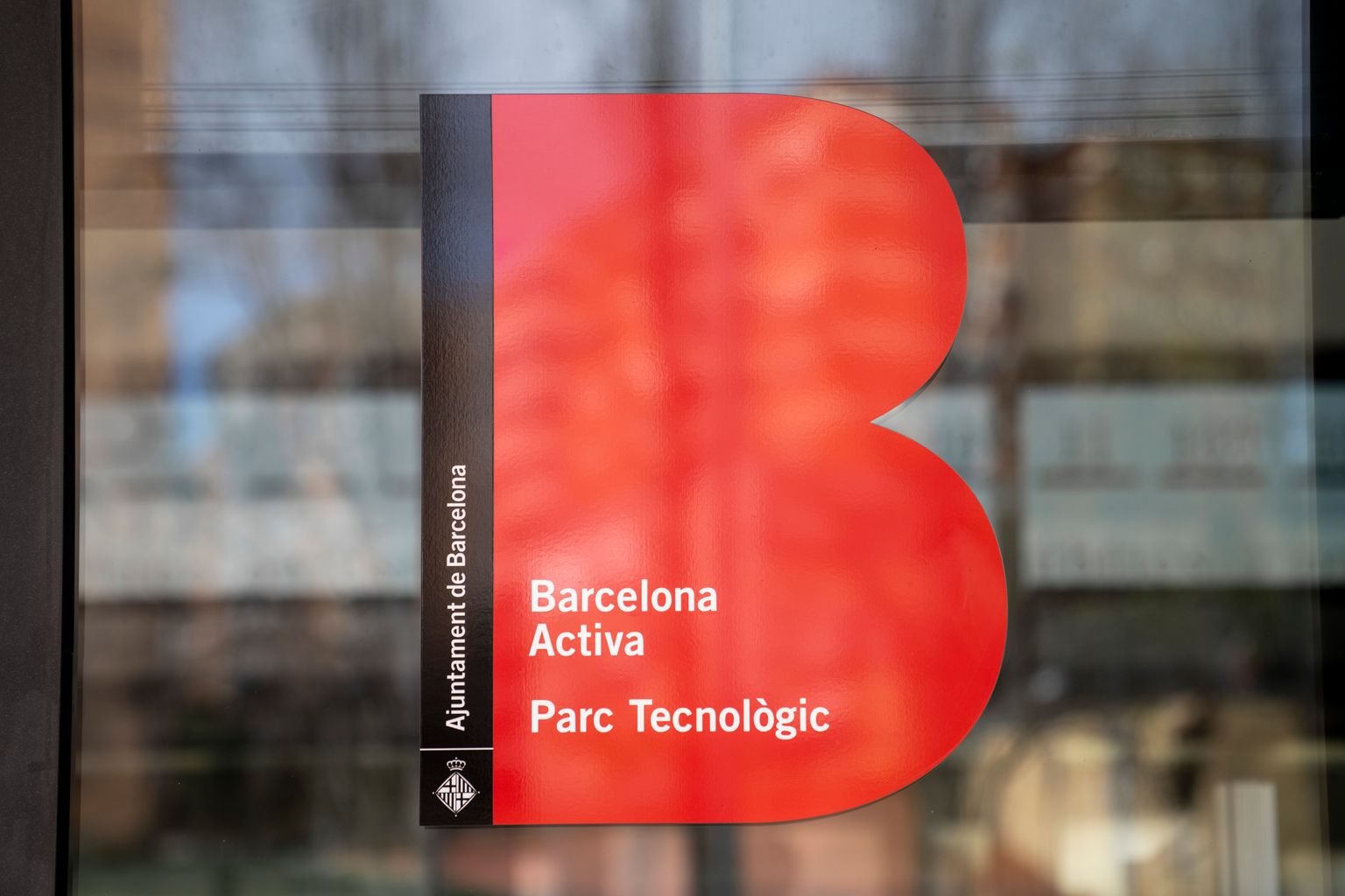 Logotip d’equipament a la porta de vidre del Parc Tecnològic de Barcelona Activa a Nou Barris