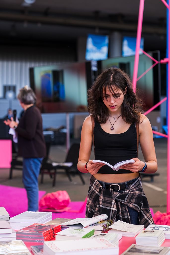 Una chica hojeando un libro en la instalación 'Asamblea nómada', del estudio H3o, durante la celebración del Día de Sant Jordi en el Festival Model