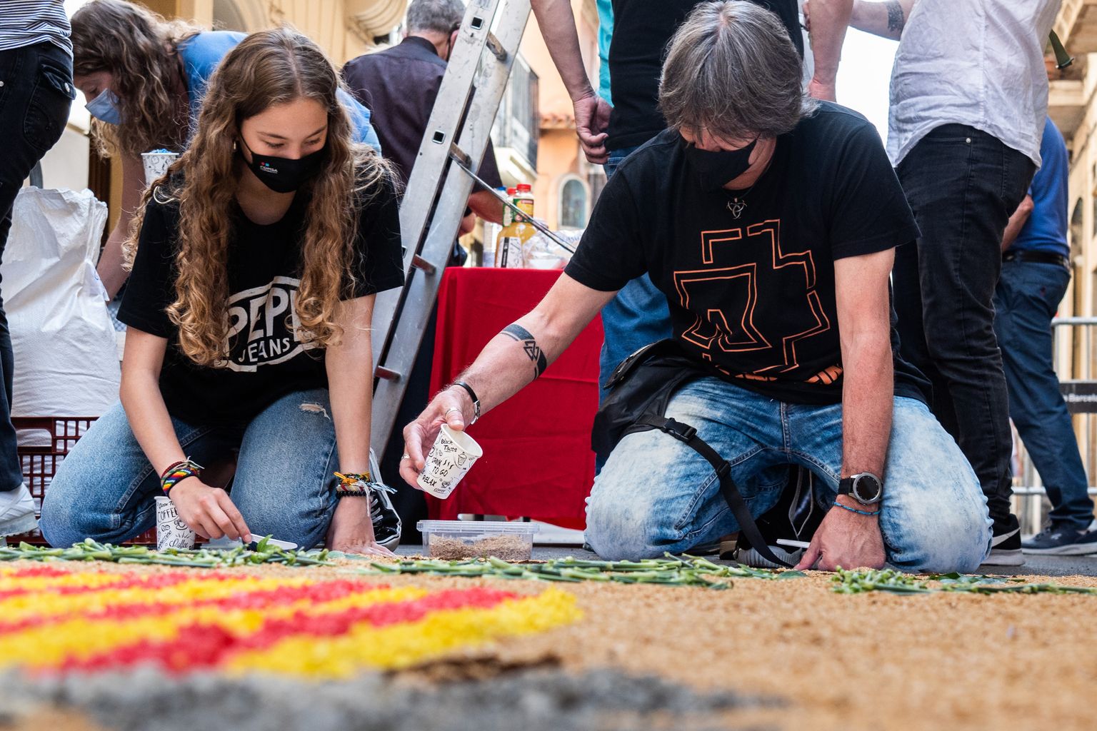 Miembros de la Comisión de Fiestas de la calle de la Llibertat elaboran la alfombra floral de la calle con motivo de la fiesta del Corpus