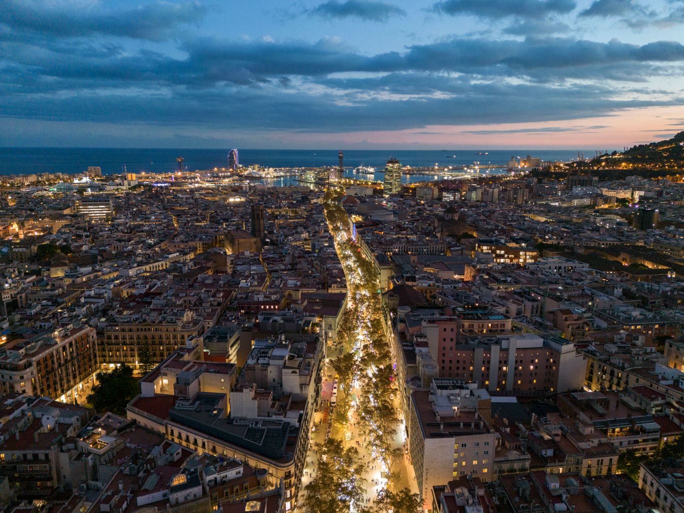Vista aérea de La Rambla al anochecer iluminada por las luces de Navidad que adornan las calles. Al fondo, el litoral y el puerto