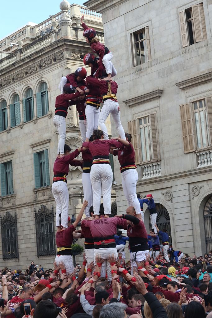 Castell de la Colla Castellera Jove de Barcelona amb els Castellers de la Vila de Gràcia construint una torre al darrera