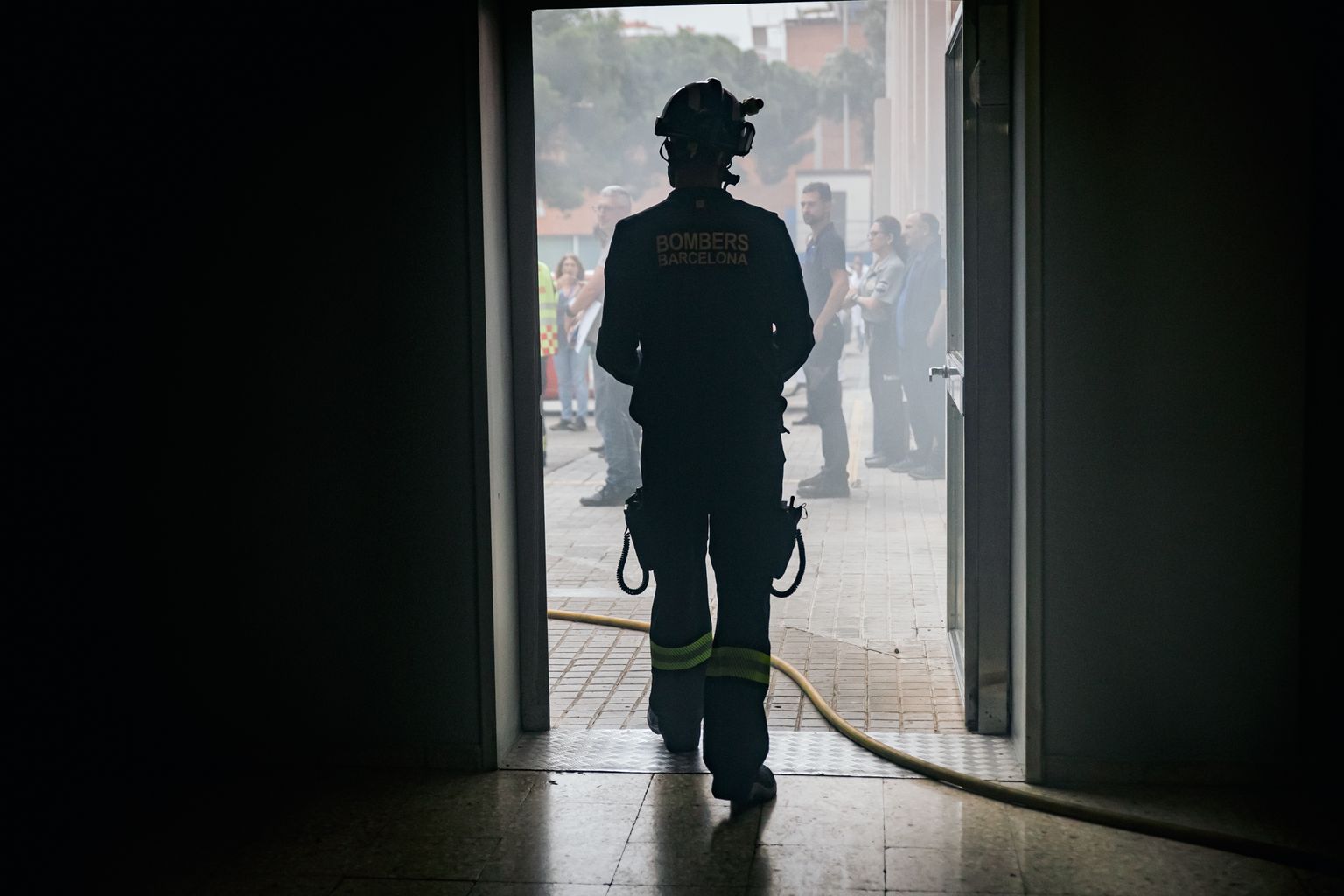 Un membre dels Bombers de Barcelona es dirigeix a l’exterior de l’edifici amb fum de l’Hospital de la Vall d’Hebron durant el simulacre d’incendi.