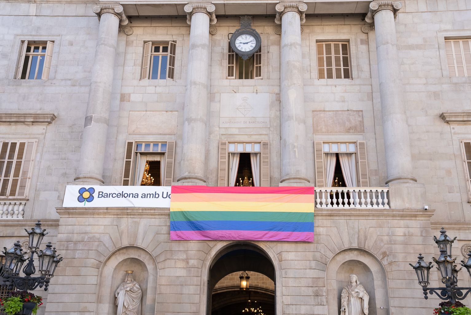 Façana de l'Ajuntament amb la bandera LGTBIQ+ penjant del balcó amb motiu del Dia de l'Orgull