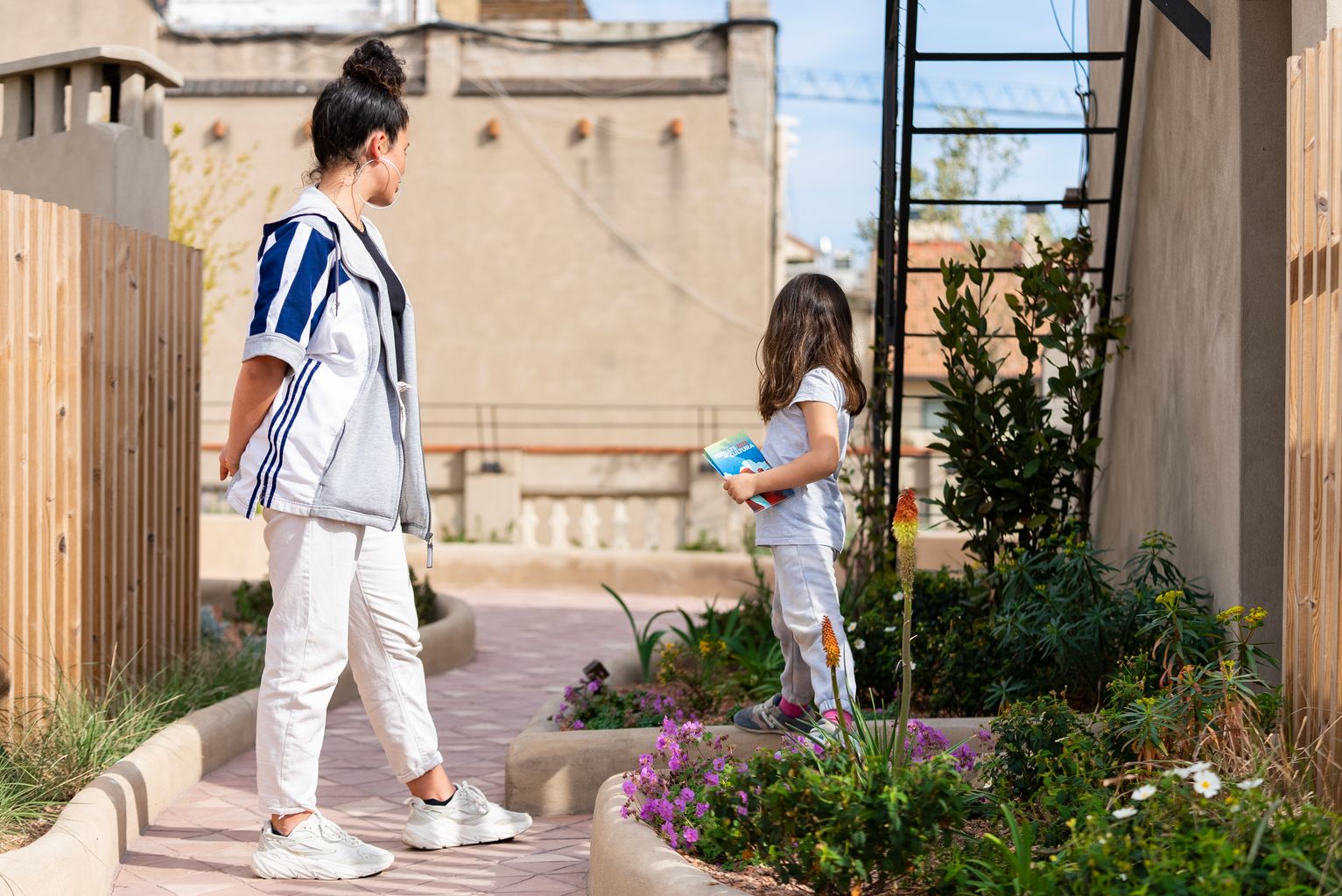 Una chica y una niña pequeña juegan durante la visita a la azotea del edificio de la calle de Provença, 268, dentro de +MODEL, "Conoce una nueva cubierta verde"
