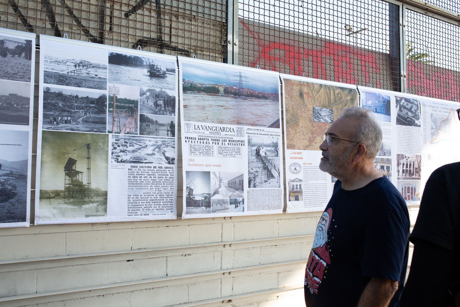 Un home mira les fotografies de l’exposició de fotografies històriques del riu Besòs i la zona que l’envolta.