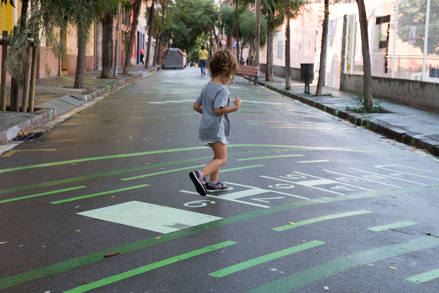 Una nena juga a la xarranca a la zona pacificada al voltant de l’Escola del Doctor Ferran i Clua al carrer de les Acàcies