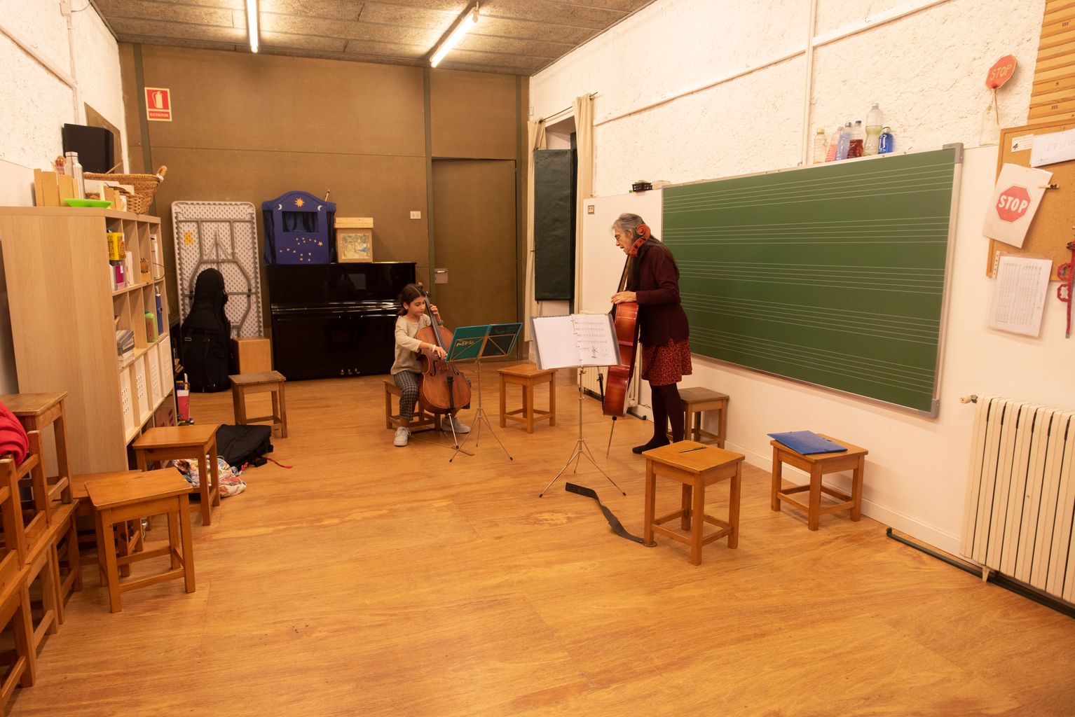 Una noia rep classe de violoncel a l'Escola Municipal de Música Can Ponsic.