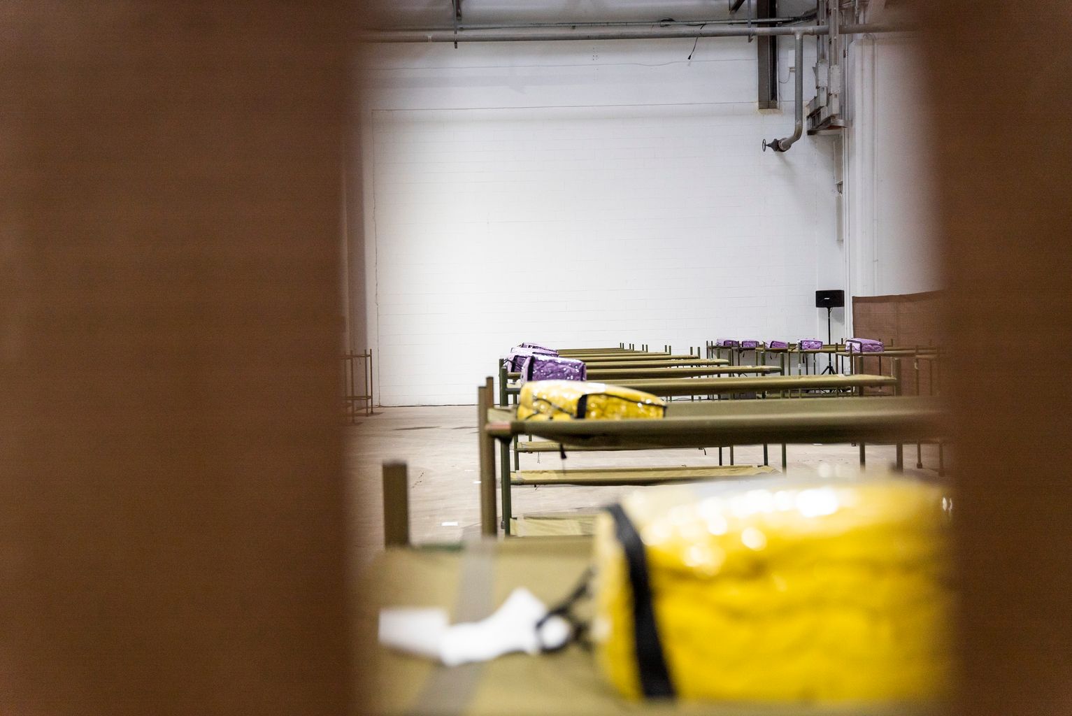 Pavelló per a persones sense llar. Sala amb lliteres i roba de llit a sobre