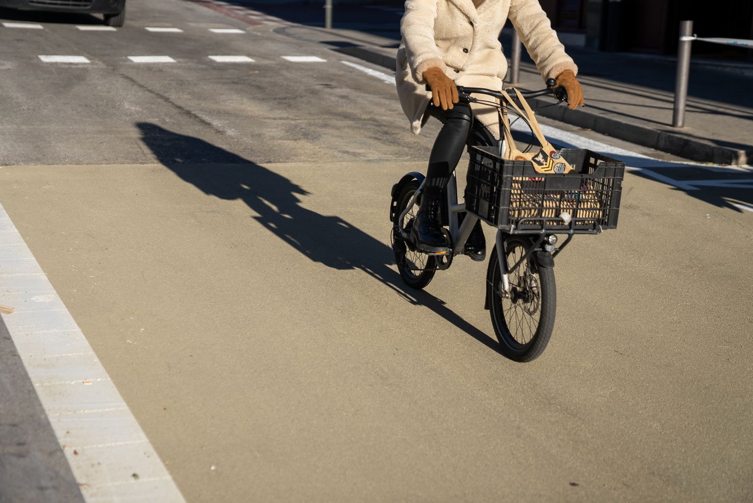 Un ciclista circula pel nou paviment reductor de l'efecte illa de calor i sonoreductor al carrer del Torrent de l'Olla