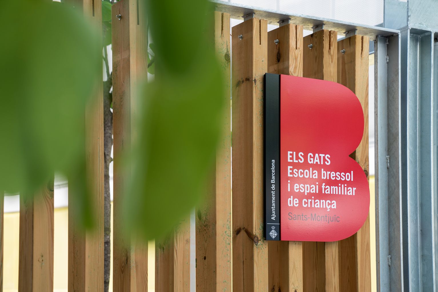 Placa d'identificació d'edifici municipal a la porta de l'escola bressol municipal Els Gats