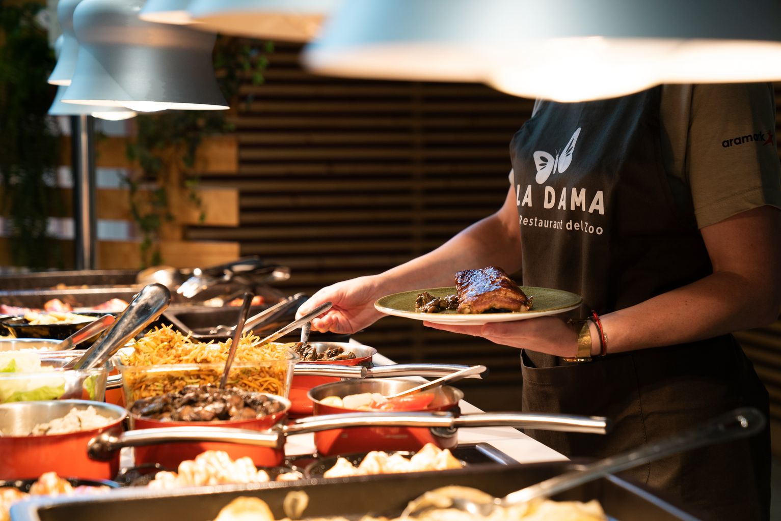 Un dels cambrers del restaurant La Dama, del Zoo de Barcelona, serveix una ració en un plat