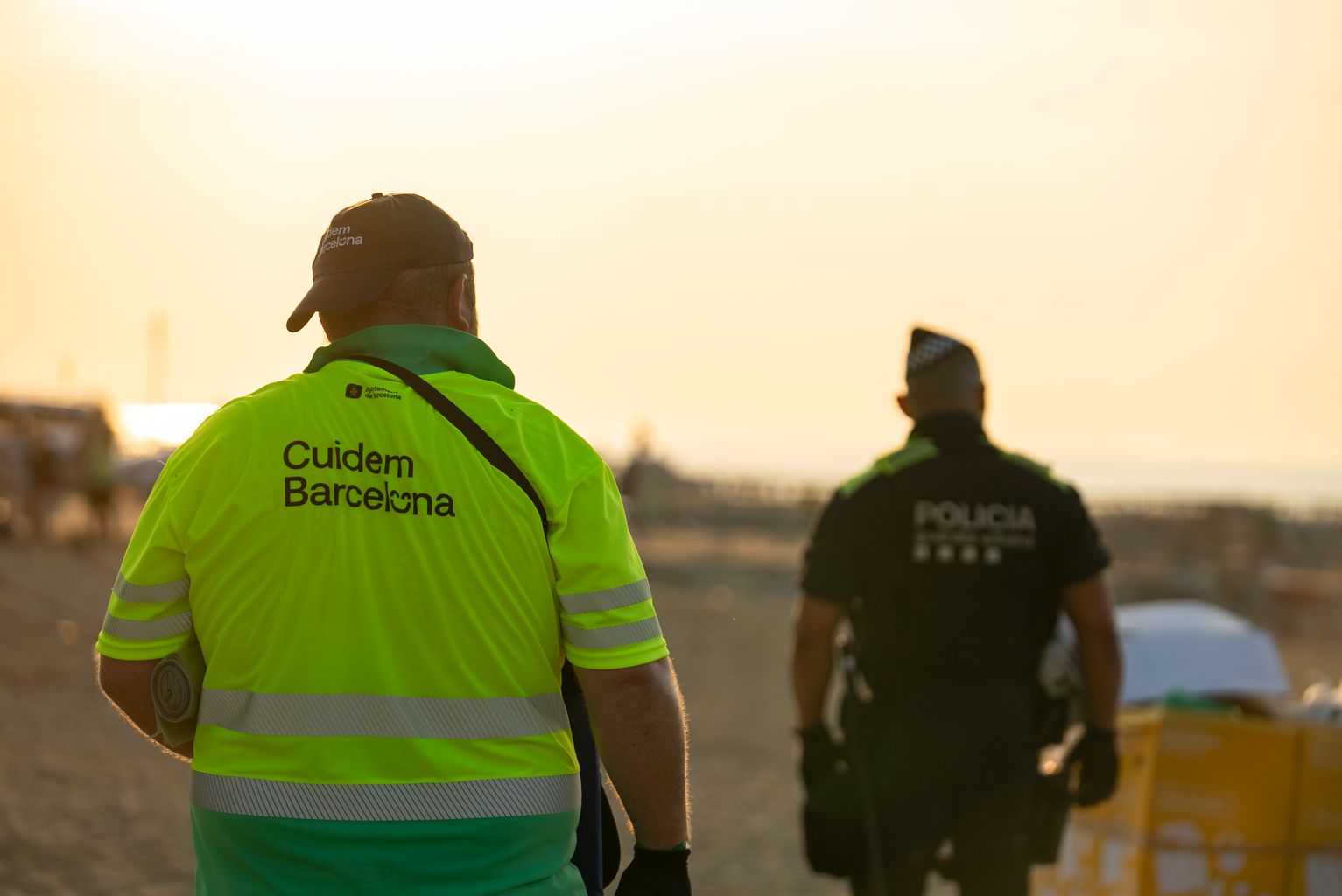 Operaris de neteja i de la Policia durant el dispositiu de neteja de platges després de la revetlla de Sant Joan.