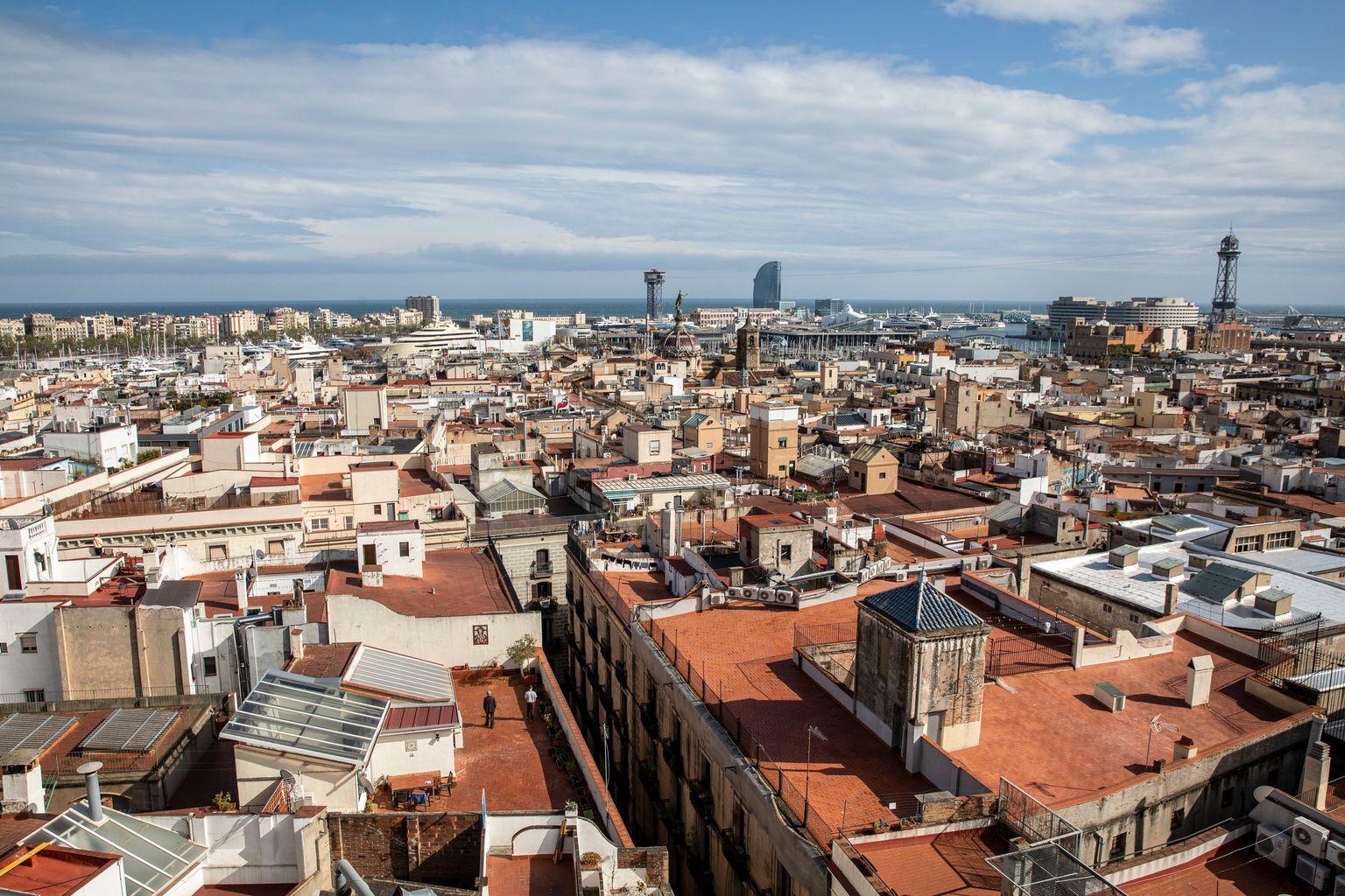 Vistes de Barcelona des del mirador de Maria Aurèlia Capmany. Vistes sobre Ciutat Vella i el Port de Barcelona. Es veu alguna persona passejant pels terrats