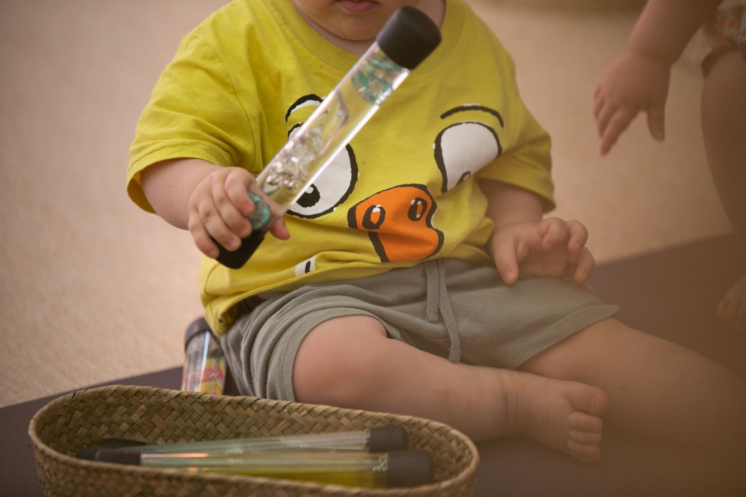 Un infant juga a l'aula amb uns tubs de líquid en una de les activitats de l'Escola Bressol Municipal Tres Turons
