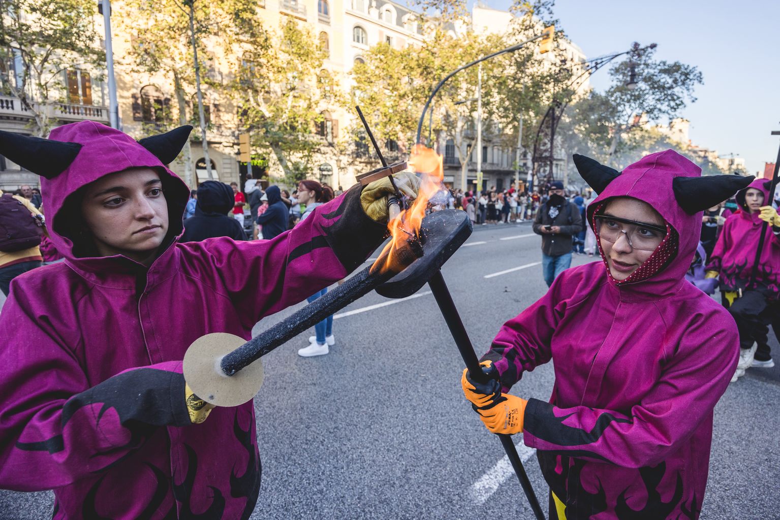 Dos joves d’una colla de diables encenen les seves torxes al correfoc petit