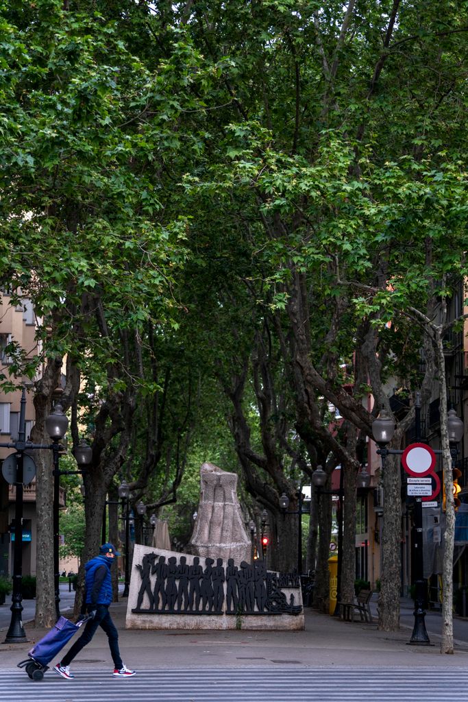 Un home amb un carretó de la compra creua el pas de vianants de la cruïlla de la rambla del Poblenou amb el carrer de Pere IV. Districte de Sant Martí. Barri del Poblenou. 
