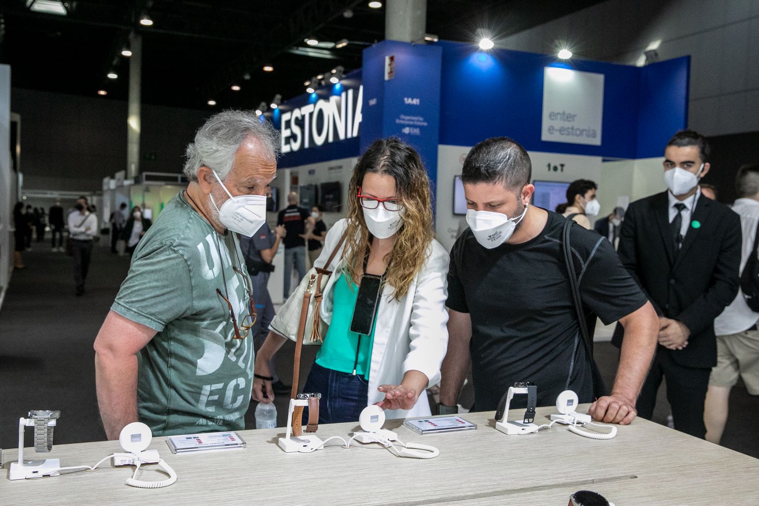 Visitants del Mobile World Congress mirant les novetats en rellotges intel·ligents d’un dels estands