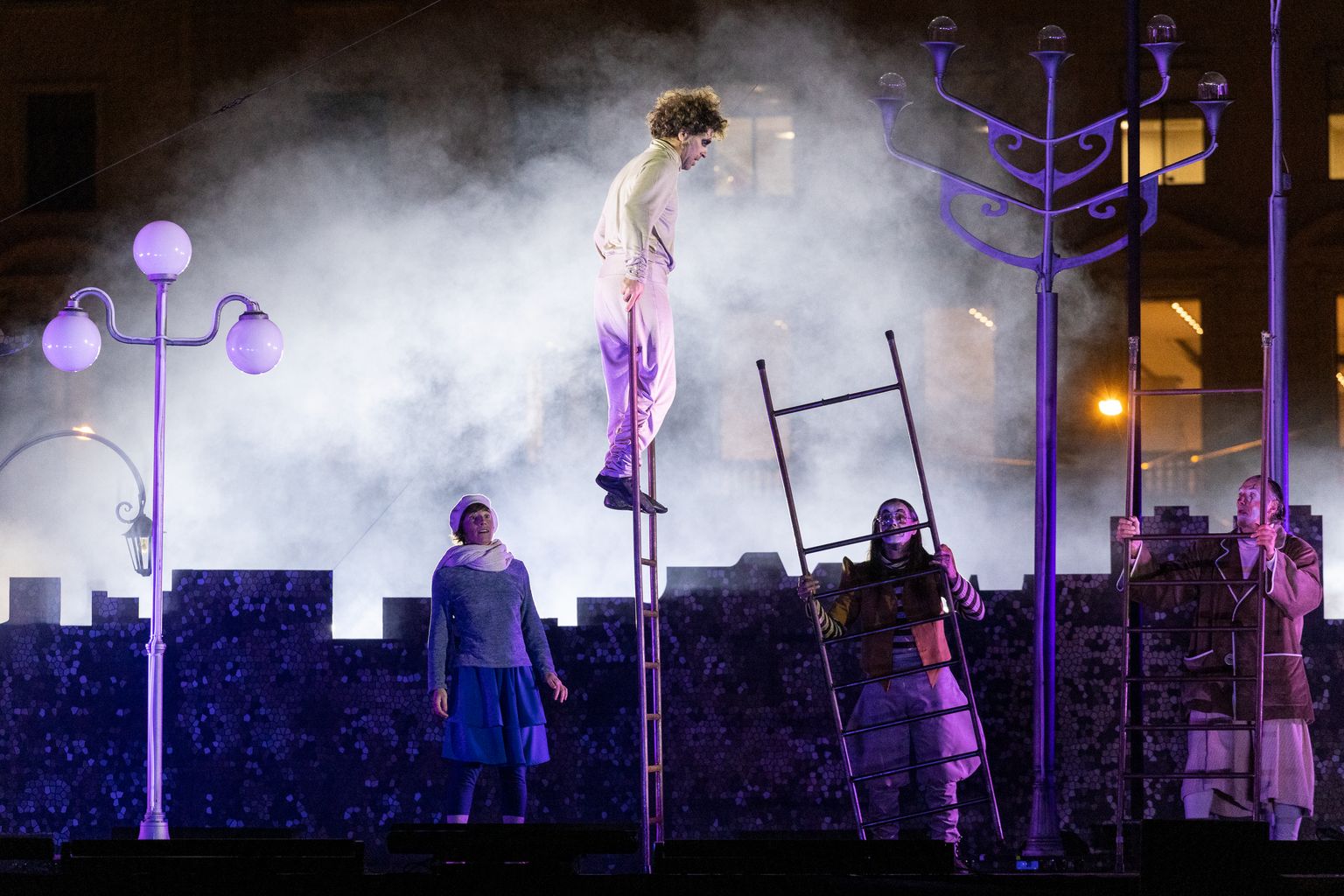Momento del espectáculo de circo y música 'Ombrana' de la compañía Ponten Pie previo al encendido de luces de Navidad en la plaza de Catalunya donde un actor hace equilibrios encima de una escalera