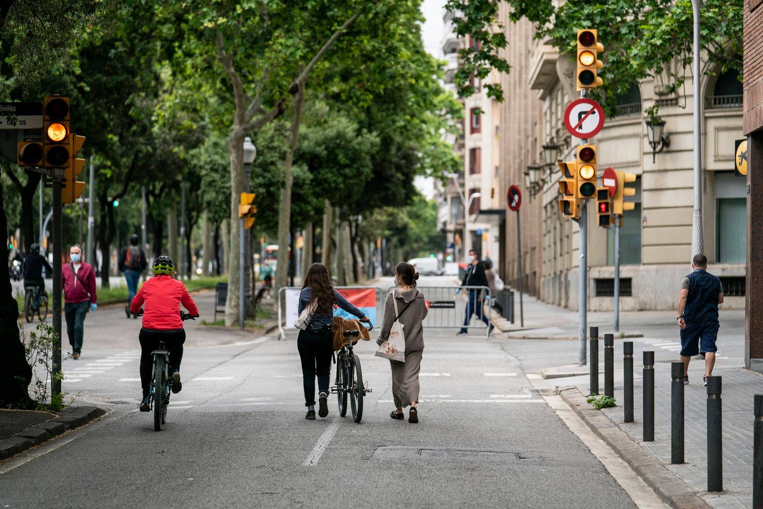 Gent caminant i en bicicleta per les zones ampliades per a vianants de la xarxa d'itineraris segurs al lateral de l'avinguda Diagonal