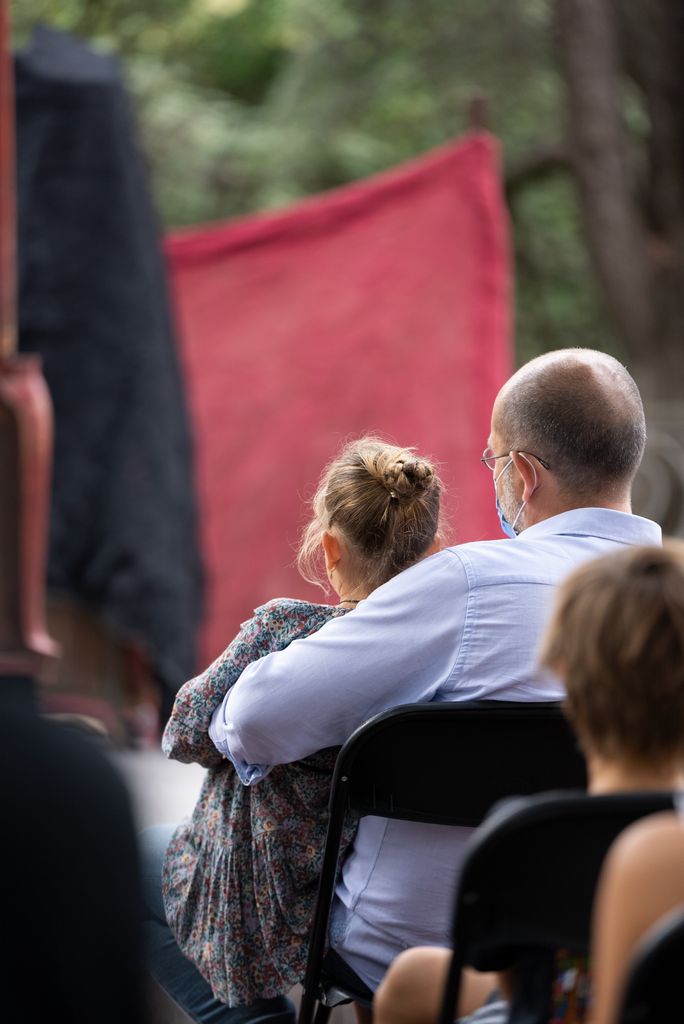 Un padre con una niña en el regazo sigue uno de los espectáculos de teatro infantil y familiar organizados en el Palacete Albéniz con motivo de La Mercè