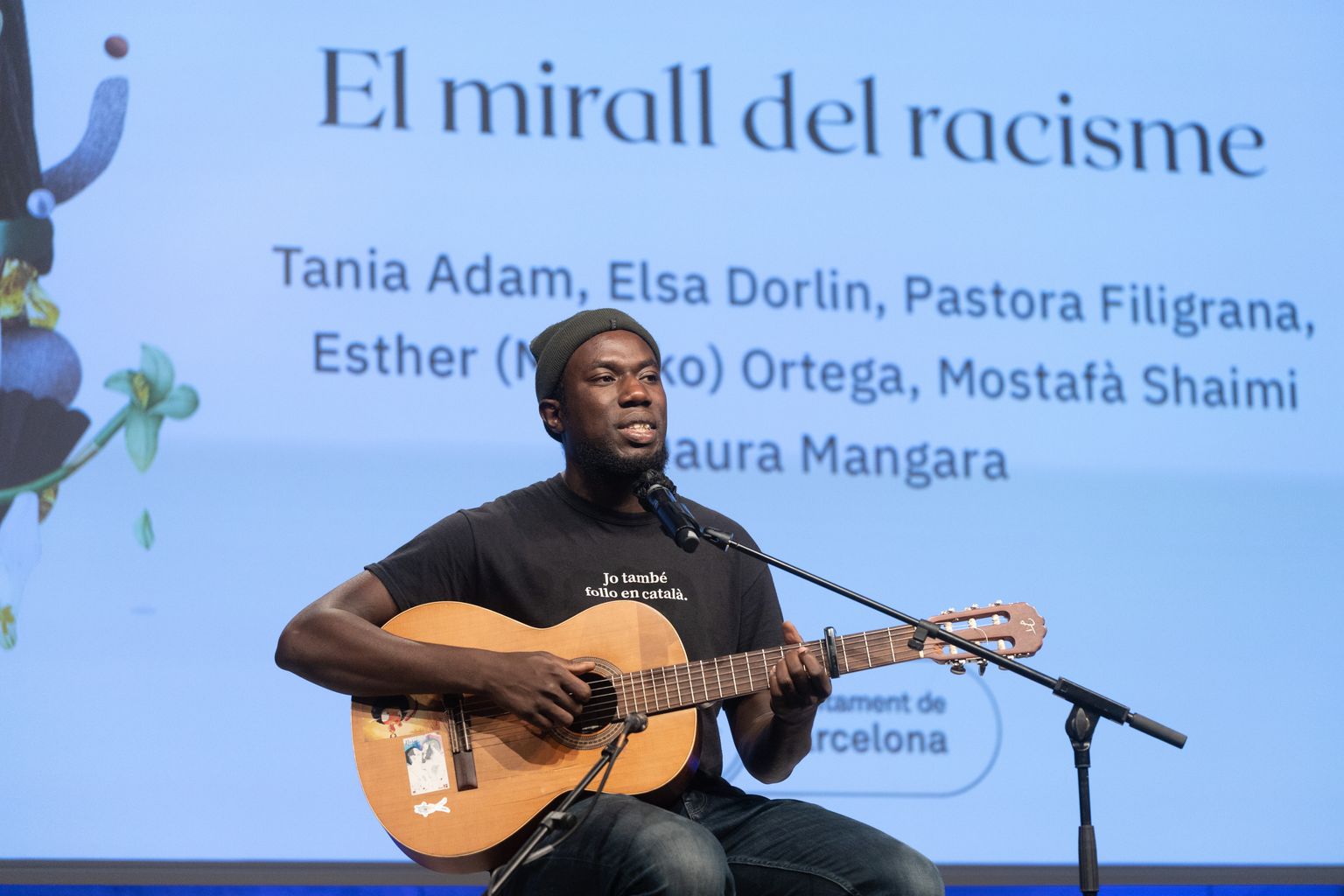 Actuación musical del artista Daura Mangara durante la mesa redonda "El espejo del racismo" en la plaza de Joan Coromines
