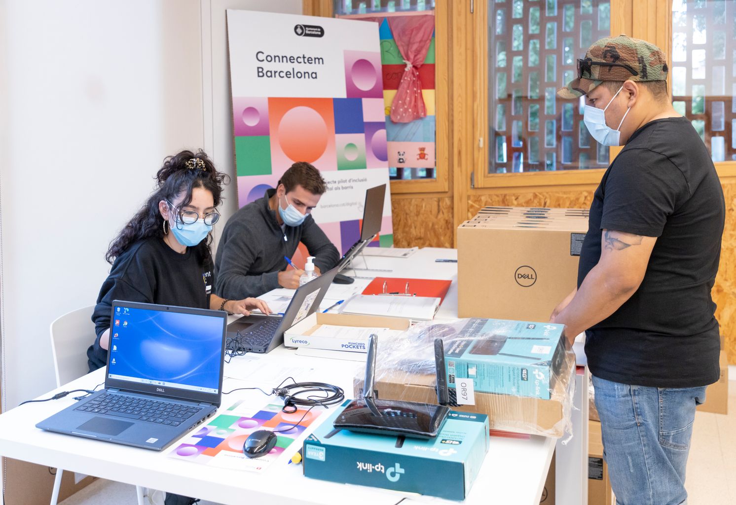 Un home recull l'equipament informàtic del projecte 'Connectem Barcelona' que es lliura a famílies de la Trinitat Nova