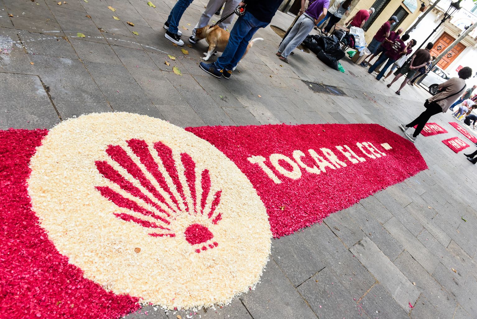 Fragment de la part acabada de la catifa floral elaborada per Corpus amb el lema 'Tocar el cel' i part de l'escut dels Castellers de Sarrià
