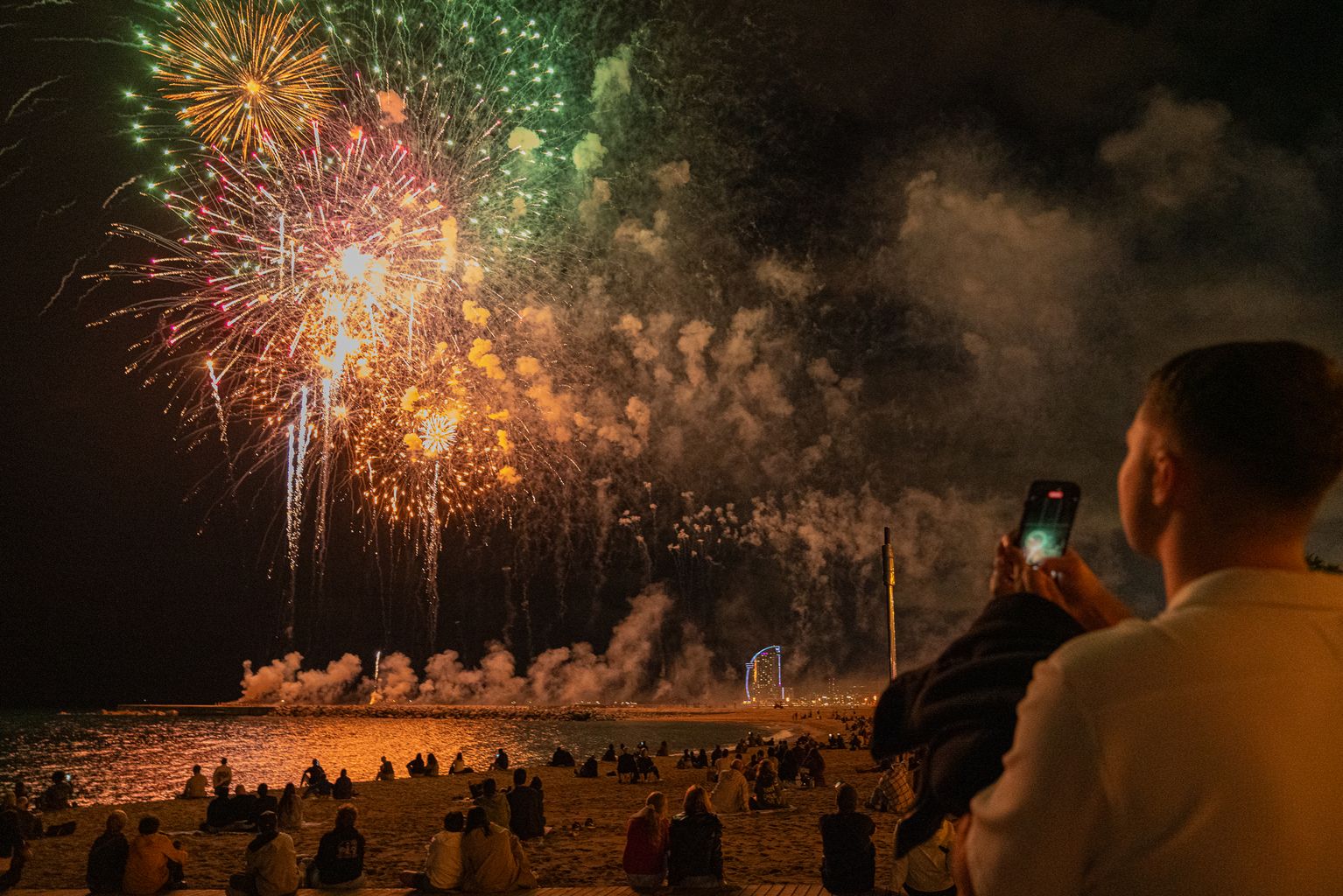Gent fotografiant els castells de focs artificials de la Pirotècnia Fantàstica participant al 25è Festival Pirotècnic Internacional a la Platja de l'Espigó del Gas
