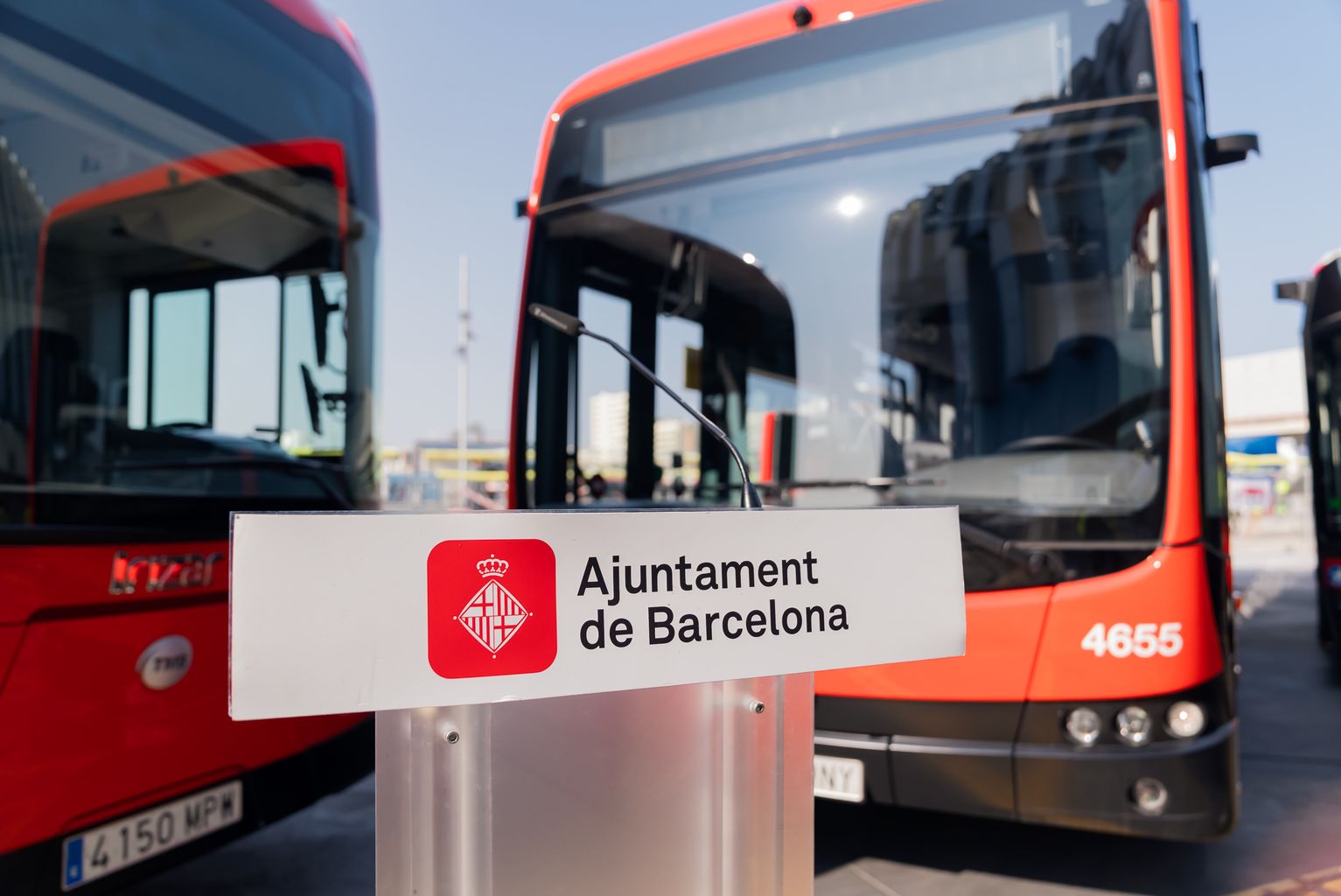 Faristol de l’Ajuntament de Barcelona davant de tres autobusos aparcats a la cotxera d’autobusos del Triangle Ferroviari